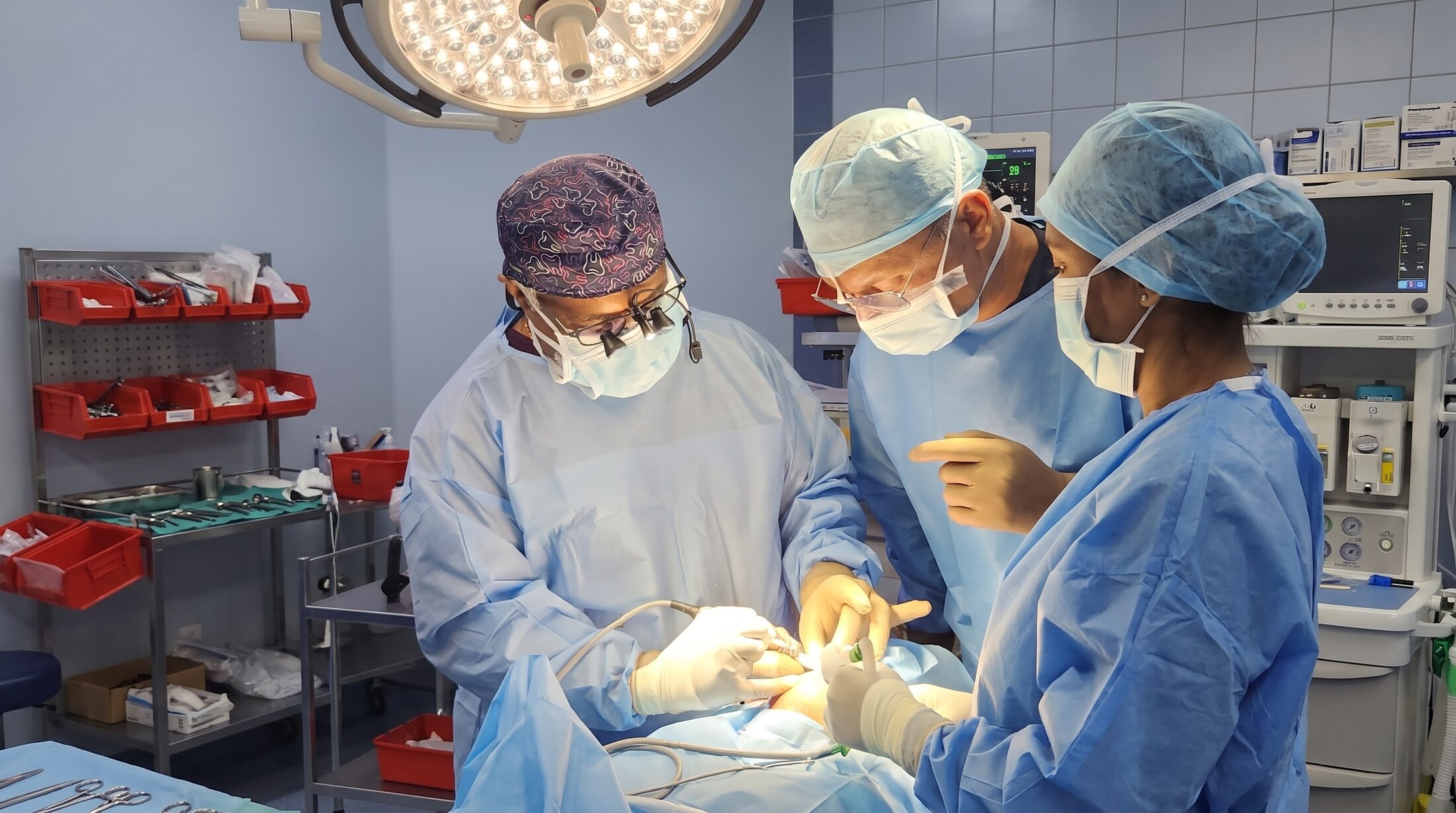The clinical team at Align Dental Care gowned and masked around a patient during a procedure.